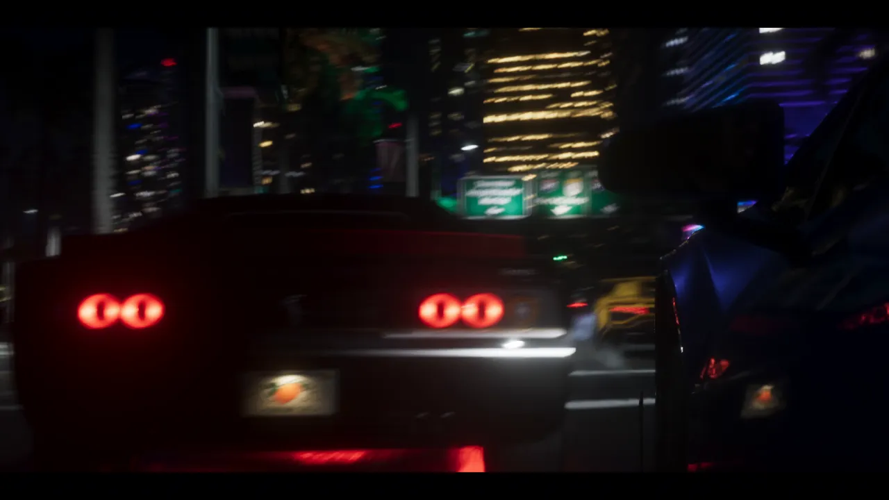 At night, the blurred rear of a sports car with double round red taillights, in front of lit towers; the license plate carries an orange.